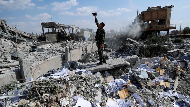 A Syrian soldier films the damage of the Syrian Scientific Research Center which was attacked by US, British and French military strikes in retaliation to President Bashar Assad’s suspected chemical attack against civilians, in Barzeh, near Damascus, Syria. Picture: AP /Hassan Ammar.