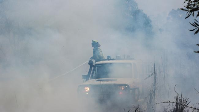 Firefighters battle to bring the bushfire on Richardson Rd, Humpty Doo, under control. Picture: Glenn Campbell