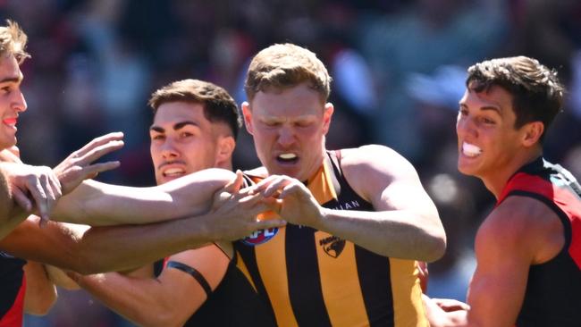 MELBOURNE, AUSTRALIA - MARCH 16: Bombers players remonstrate with James Sicily of the Hawks after he gave away a free kick to Andrew McGrath of the Bombers during the round one AFL match between Essendon Bombers and Hawthorn Hawks at Melbourne Cricket Ground, on March 16, 2024, in Melbourne, Australia. (Photo by Quinn Rooney/Getty Images)