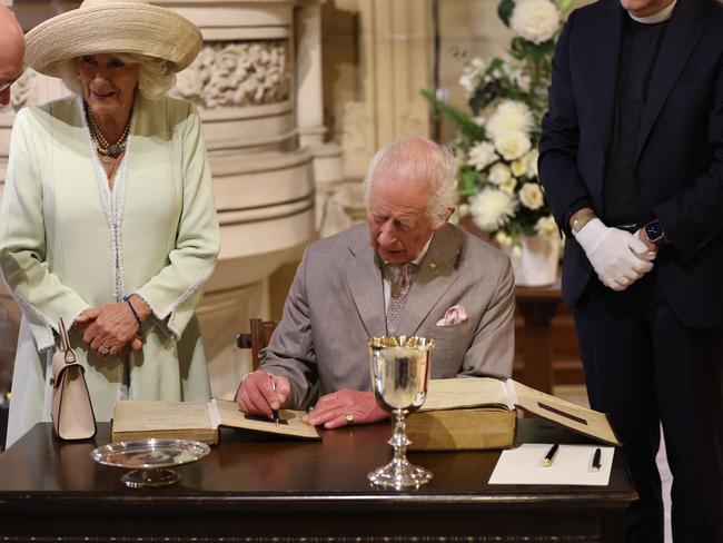 The monarch signs a historic Bible. Picture: Rohan Kelly