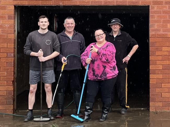 (L-R) Mark Larkins, John Larkins, Irena Ibrahim and Syd Burton working together to clean up their building for the third time in four months, as floods hit again. Picture: Paul Brescia/NewsLocal