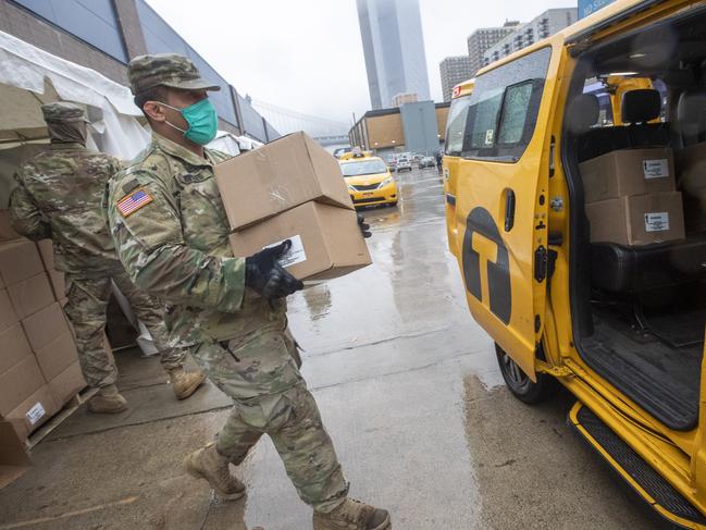 A member of the United States National Guard loads boxes of prepared meals into a taxi for distribution to people in need in New York. Picture: AP