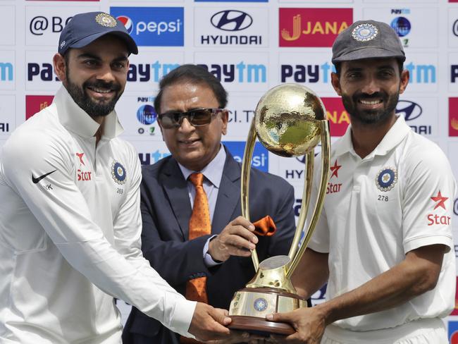 Virat Kohli and Ajinkya Rahane receive the Border-Gavasker Trophy from Sunil Gavaskar.