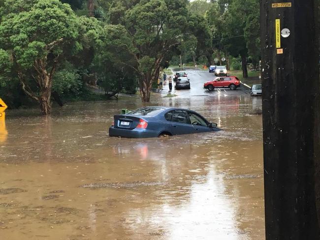 A car submerged in floodwaters on the corner of Station St and McNicol Rd in Belgrave. Picture: Michael Colling