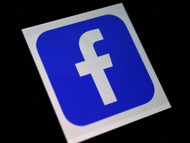 (FILES) This file photo illustration shows a Facebook App logo  displayed on a smartphone on March 25, 2020 in Arlington, Virginia. - Facebook said on February 18, 2021, it would expand its climate information hub and direct its users to experts to debunk myths and hoaxes in the field in a ramped up effort to fight misinformation. (Photo by Olivier DOULIERY / AFP)