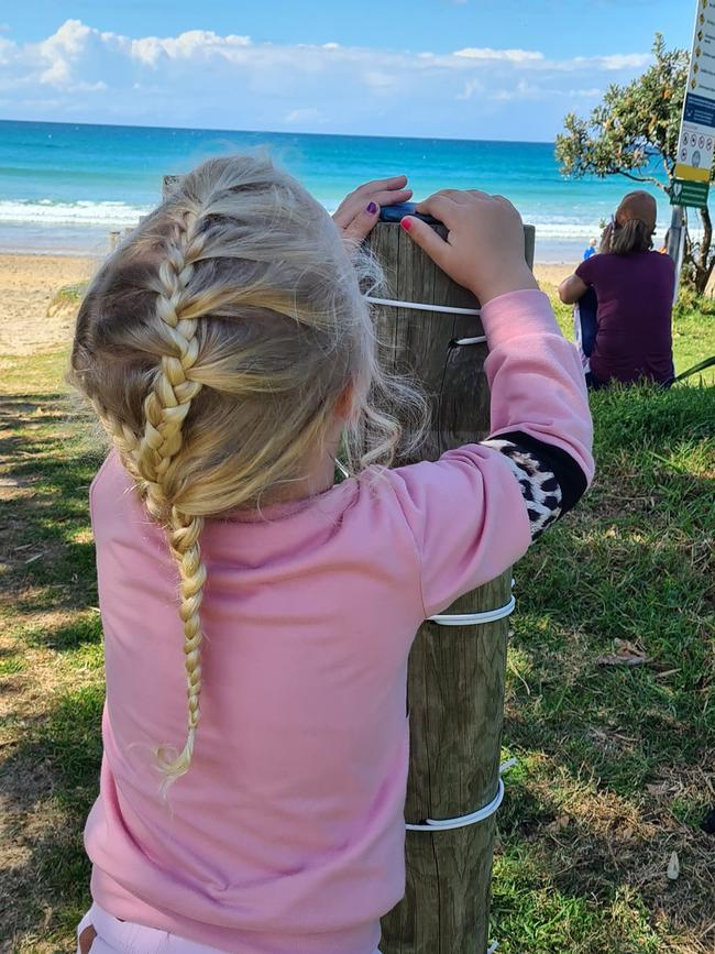 Ariel places a small number of handpainted rocks for people to find at Emerald Beach.