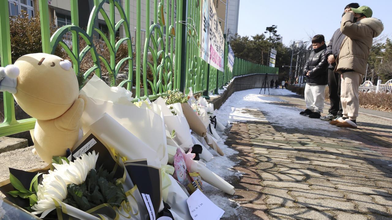 People mourn the death of a pupil stabbed to death allegedly by a teacher, outside of an elementary school in Daejeon, South Korea, Tuesday, Feb. 11, 2025. (Kang Soo-hwan/Yonhap via AP)