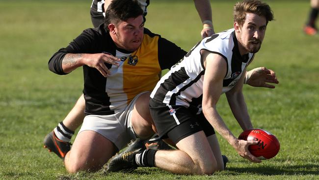  Lachie Caine, the son of Clayton president Bob, gets away a handball for the Clays.