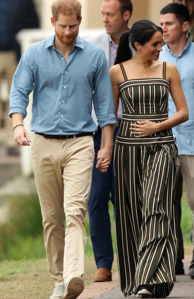 The Duchess of Sussex was pictured cradling her baby bump during the Bondi visit while walking with Prince Harry.