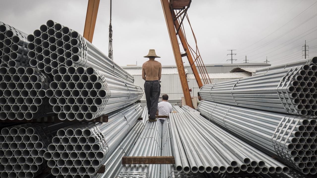 Workers prepare to lift bundles of steel pipe with a crane at a stockyard on the outskirts of Shanghai, China. Picture: Qilai Shen/Bloomberg