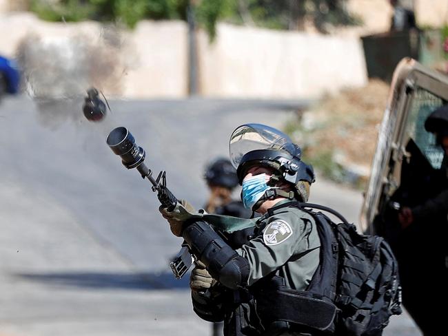 An Israeli border police member fires a tear gas canister towards Palestinians protesting against the demolition of a house under construction by Israeli forces, in Beitunia in the Israeli-occupied West Bank, June 24, 2020. REUTERS/Mohamad Torokman     TPX IMAGES OF THE DAY - RC2KFH9ROT1U