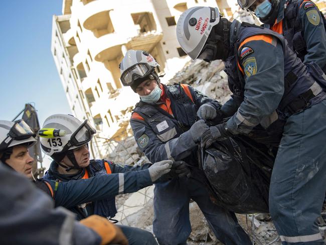 Russian rescue workers retrieve a body from the rubble of a collapsed building in the regime-controlled town of Jableh in the province of Latakia, northwest of the capital Damascus. Picture: AFP