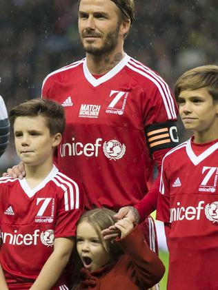 David Beckham, upper left, stands with his children Cruz, left, Harper, bottom, and Romeo before the Unicef Match for Children charity football match between a Great Britain and Ireland team and a Rest of the World team at Old Trafford Stadium, Manchester, England, Saturday, Nov. 14, 2015. (AP Photo/Jon Super)