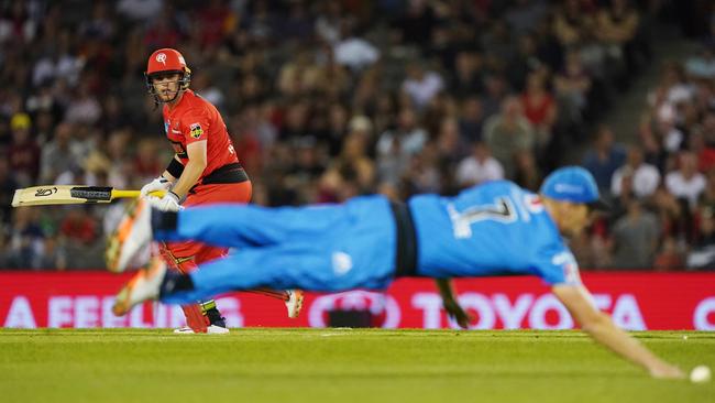 Marcus Harris of the Renegades hits past Cameron White of the Strikers at Marvel Stadium.