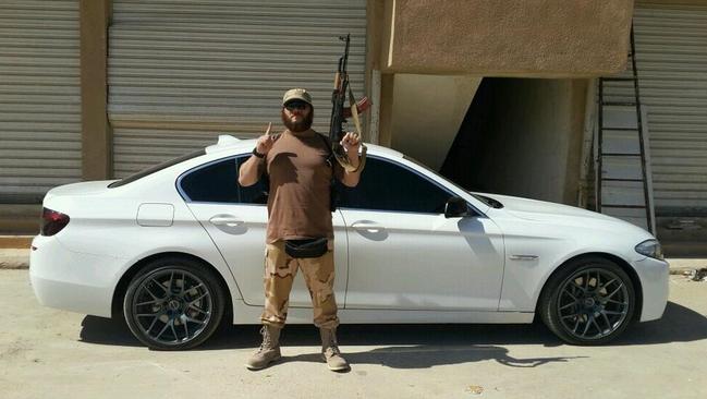 Khaled Sharrouf posing with an AK-47 in front of a sports car from an undisclosed location within Iraq.