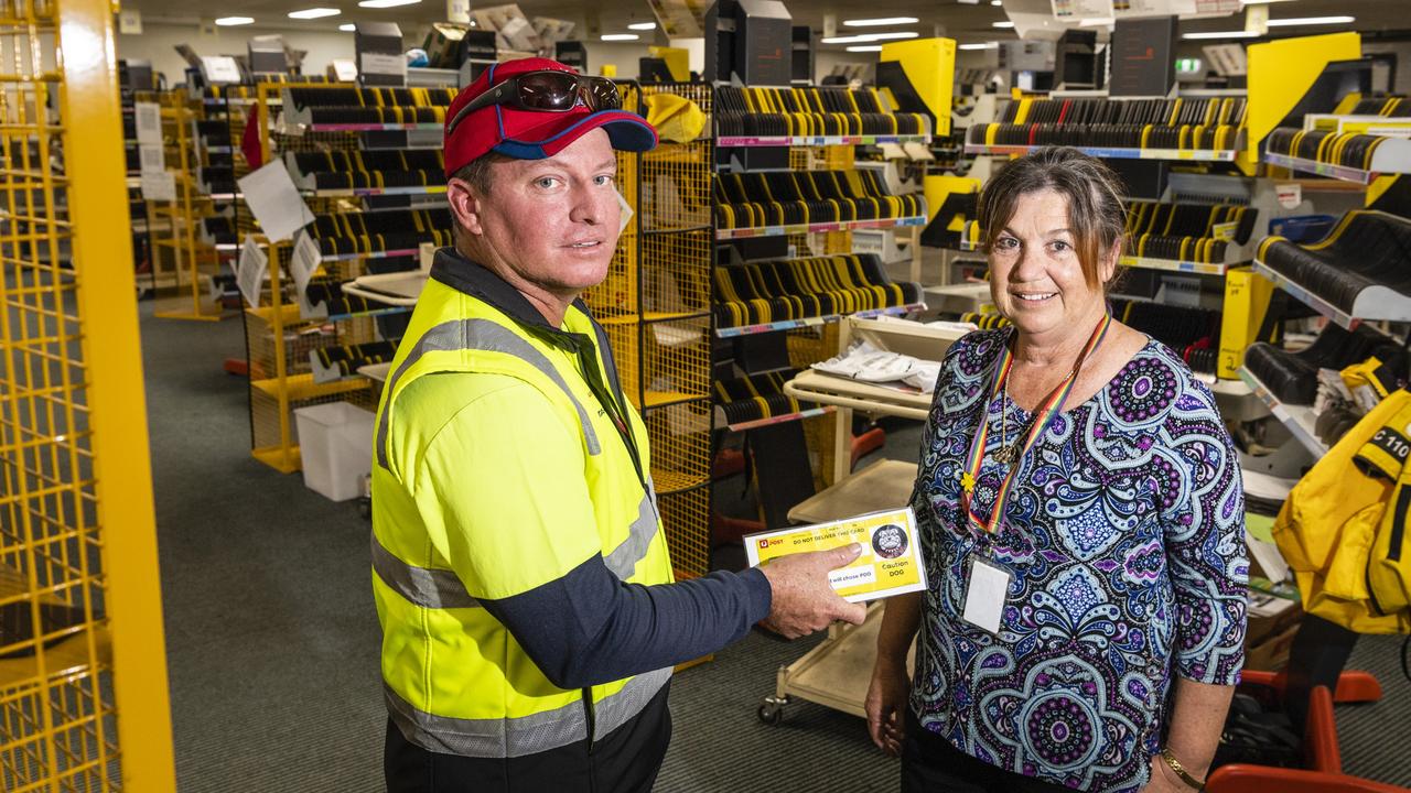 Australia Post postie Matt Gaske and Australia Post delivery manager Susan Mason talk while exchanging a hazard card used to report problematic addresses between posties. Picture: Kevin Farmer