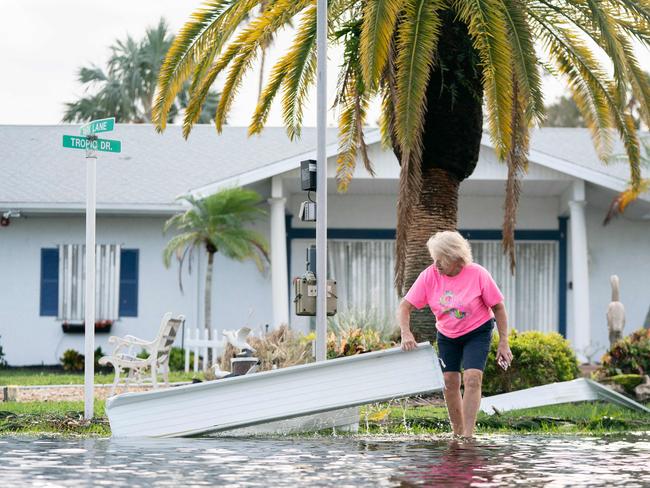 A woman moves storm debris in Osprey, Florida. (Photo by Sean Rayford / GETTY IMAGES NORTH AMERICA / Getty Images via AFP)