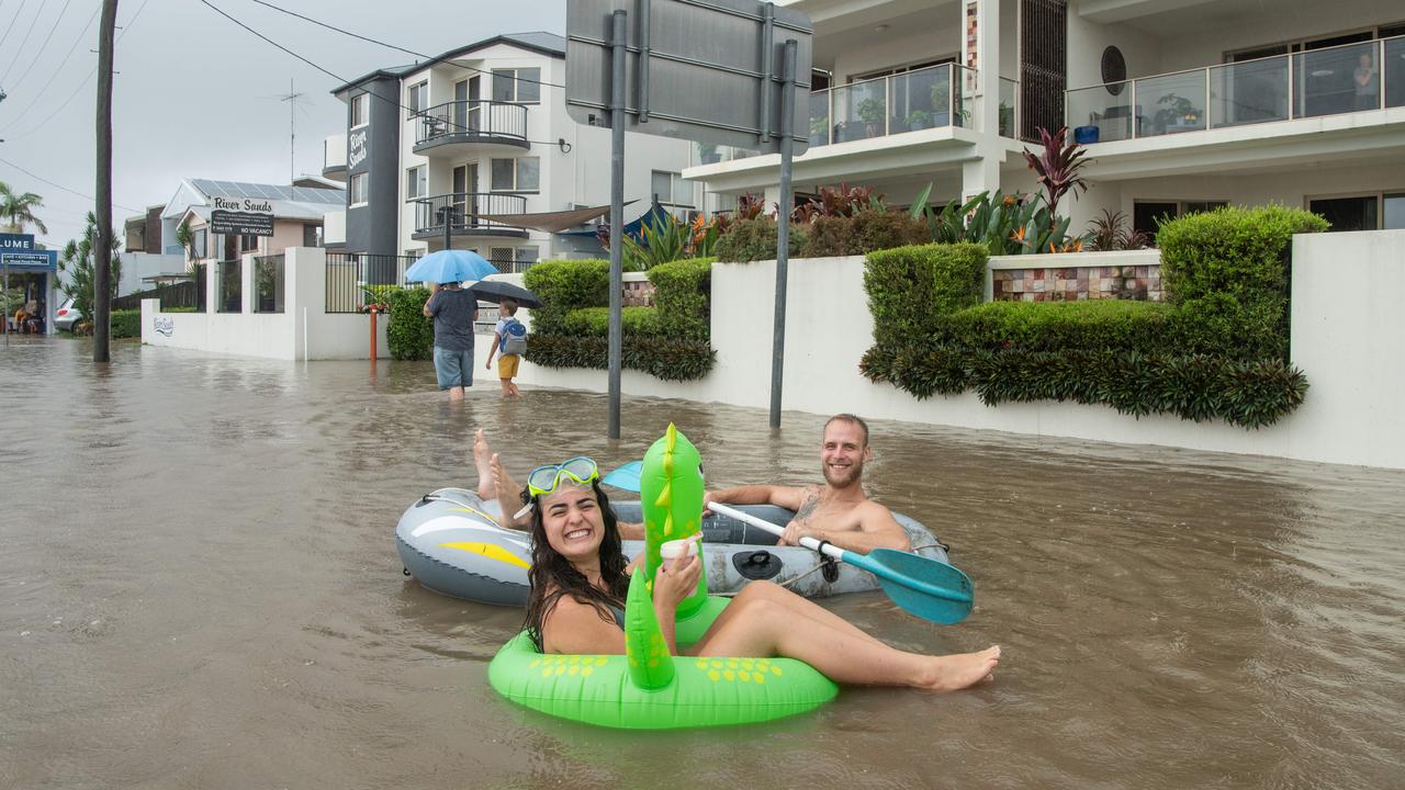 Backpackers Steffen d’Atolonia and Lauren Gomes make the most of the floods as they wait for their Bradman Ave house to flood. Picture: Brad Fleet