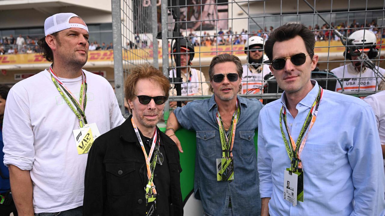 US film producer Jerry Bruckheimer, US actor Brad Pitt and US film director Joseph Kosinski at the United States Grand Prix. Photo by Patrick T. FALLON / AFP.