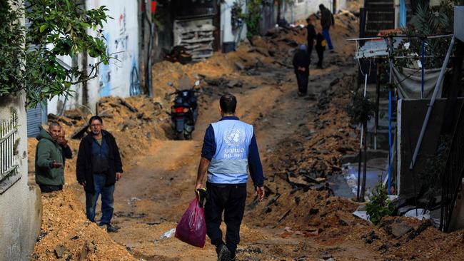 A man wearing a jacket of the UN agency for Palestinian refugees (UNWRA) walks on a street which has been bulldozed by the Israeli forces during a raid in Jenin.