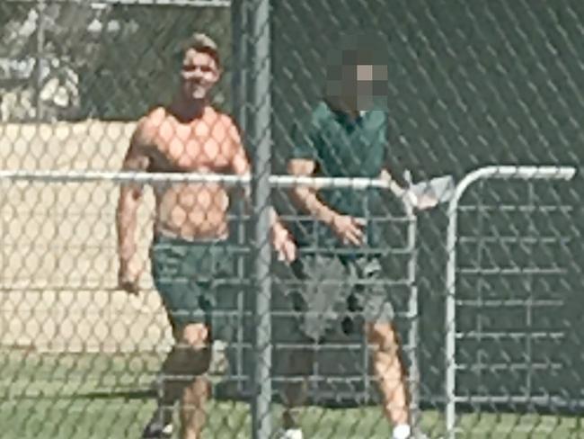 A muscled-up Oliver Curtis walks around Cooma Jail with his shirt off.