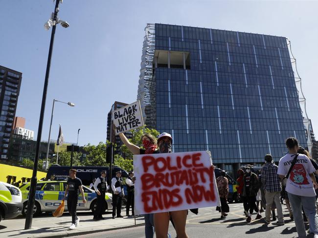 Demonstrators hold up placards outside the U.S. embassy after people marched there from Trafalgar Square in central London.