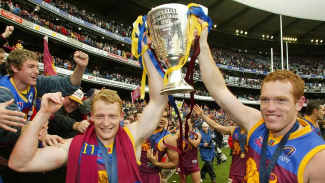 Michael Voss and Justin Leppitsch show off Brisbane’s 2002 premiership cup.