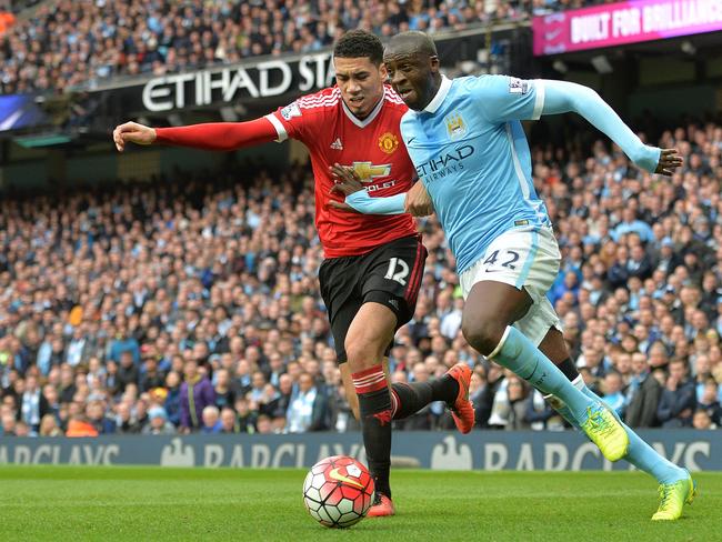 Manchester United's Chris Smalling (L) vies with Manchester City's Yaya Toure.