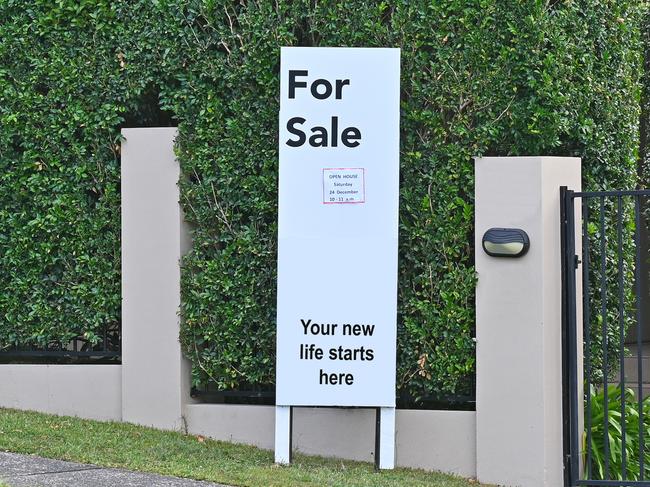 Real estate for sale sign in front of a house