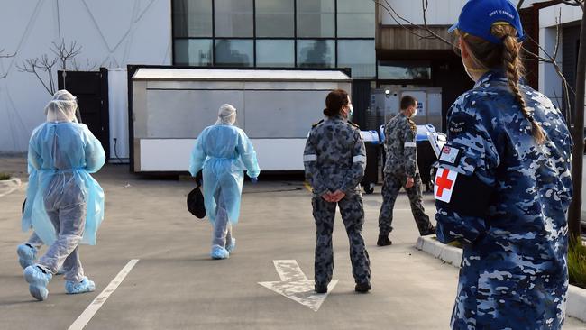 Australian Defence Force personnel escort their staff into the Epping Gardens aged care facility. Picture: William West