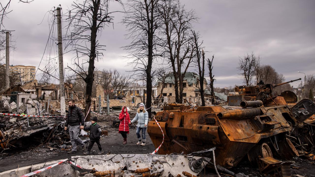 Residents walk amid debris in Bucha, where Russian forces are accused of committing a ‘deliberate massacre’. Picture: Chris McGrath/Getty Images