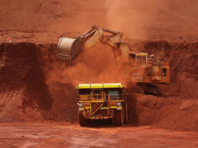 An excavator loads ore into an autonomous dump truck at Fortescue Metals Group Ltd.'s Solomon Hub mining operations in the Pilbara region, Australia, on Thursday, Oct. 27, 2016. Shares in Fortescue, the world's No. 4 iron ore exporter, have almost trebled in 2016 as iron ore recovered, and the company cut costs and repaid debt. Photographer: Brendon Thorne/Bloomberg via Getty Images