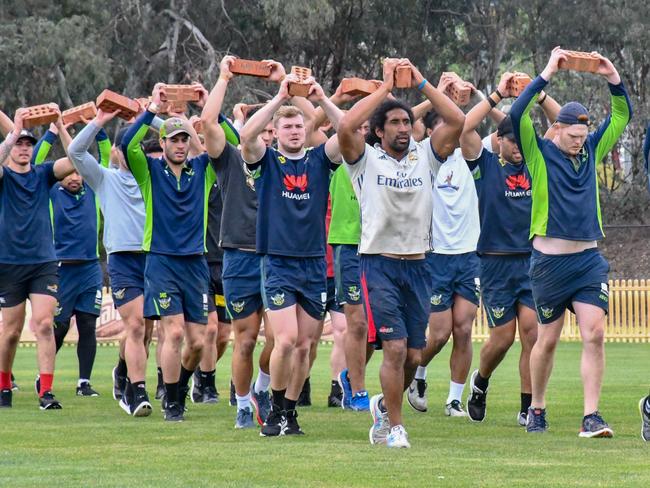 The Canberra Raiders players run while holding bricks over their heads at their ‘torture camp. Picture: Supplied