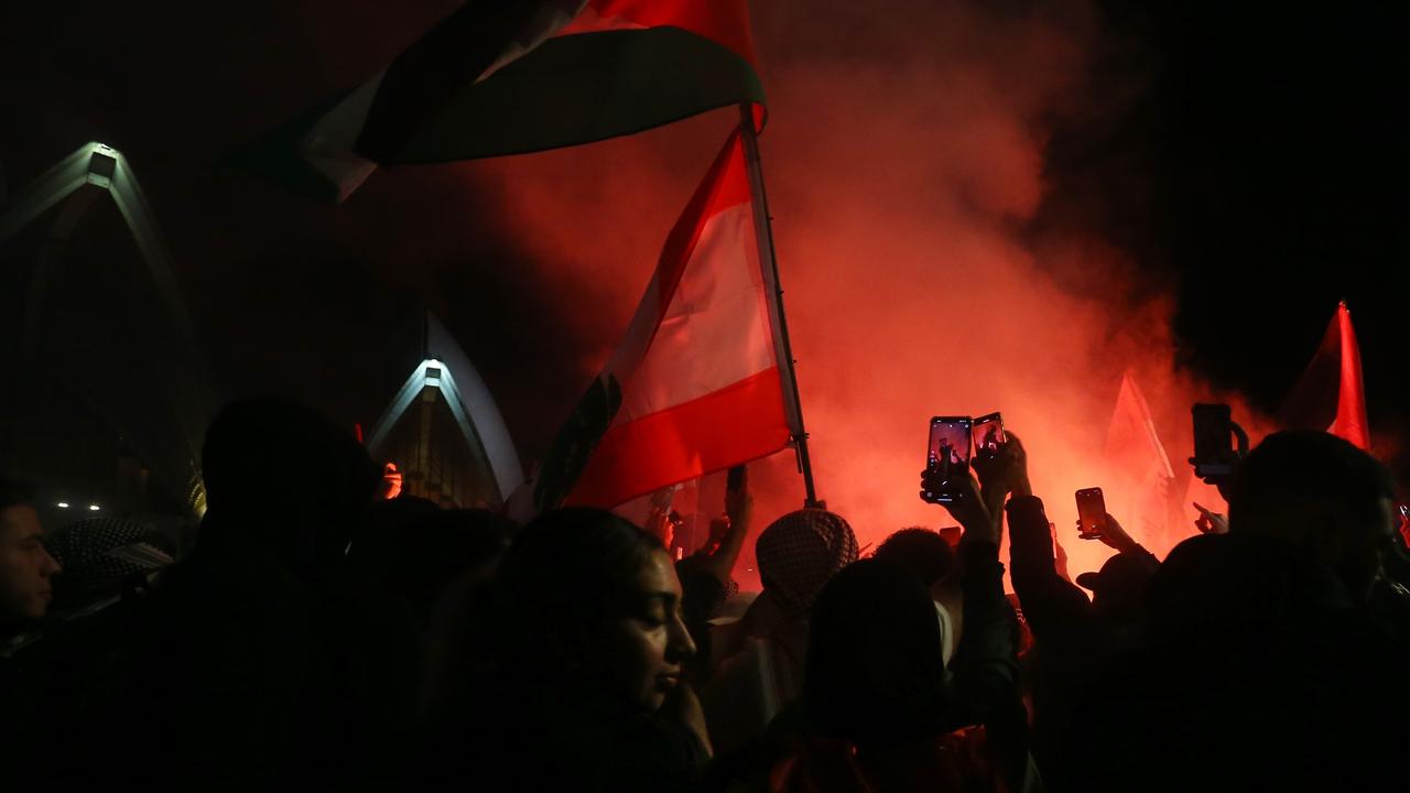 Palestine supporters ignite flares during a rally outside the Sydney Opera House on October 09. Picture: Lisa Maree Williams/Getty Images)