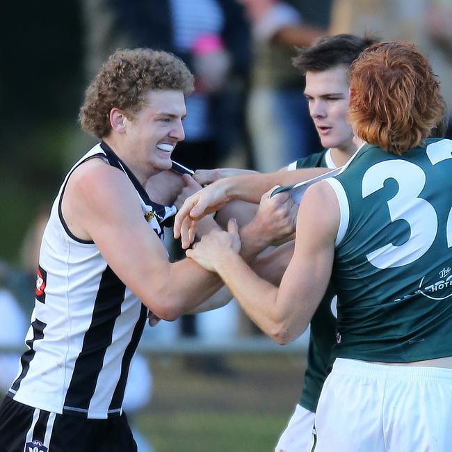 Euroa’s Nathan Stewart tangles with two Echuca opponents. Pictures: Yuri Kouzmin