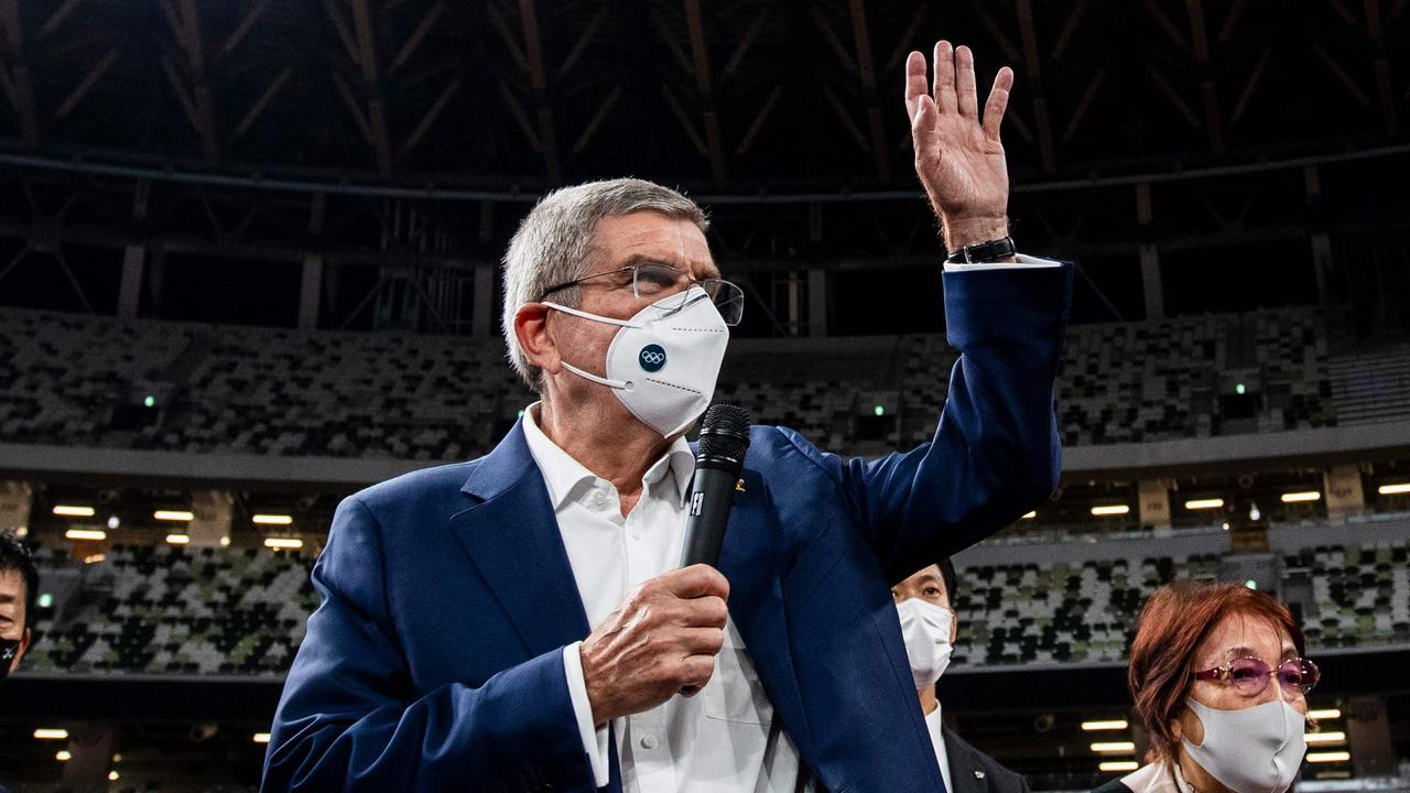 رئیس کمیته بین المللی المپیک (IOC) ، توماس باخ (C) ، با ماسک صورت ، هنگام صحبت با رسانه ها هنگام بازدید از استادیوم ملی ، محل اصلی بازی های المپیک و پارالمپیک 2020 ، موج می زند به دلیل ویروس کرونا ویروس COVID-19 ، در توکیو در 17 نوامبر 2020. (عکس بهروز مهری و بهروز مهری / استخر / خبرگزاری فرانسه)
