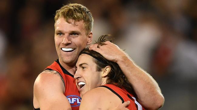 Jake Stringer (left) and Andrew McGrath of the Bombers react after McGrath kicked a goal during the Round 3 AFL match between the Melbourne Demons and the Essendon Bombers at the MCG in Melbourne, Friday, April 5, 2019. (AAP Image/Julian Smith) NO ARCHIVING, EDITORIAL USE ONLY