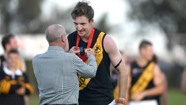 Glenelg’s Sam Durdin receives the Bob Quinn Medal from Quinn's son, Greg, on Anzac Day. Picture: Tricia Watkinson.