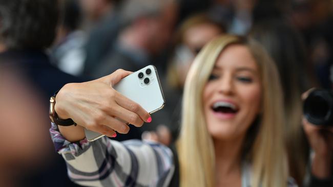 A woman tries out a new Apple 11 Pro during an Apple product launch event at Apple's headquarters in Cupertino, California on Tuesday, on September 10, 2019. - Apple unveiled its iPhone 11 models Tuesday, touting upgraded, ultra-wide cameras as it updated its popular smartphone lineup and cut its entry price to $699. (Photo by Josh Edelson / AFP)