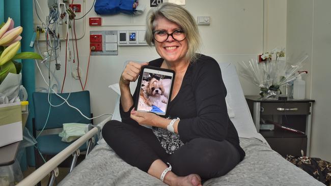 Dr Sally Cockburn at The Alfred hospital with a photo of her beloved dog Molly, who helped save her life. Picture: Tony Gough