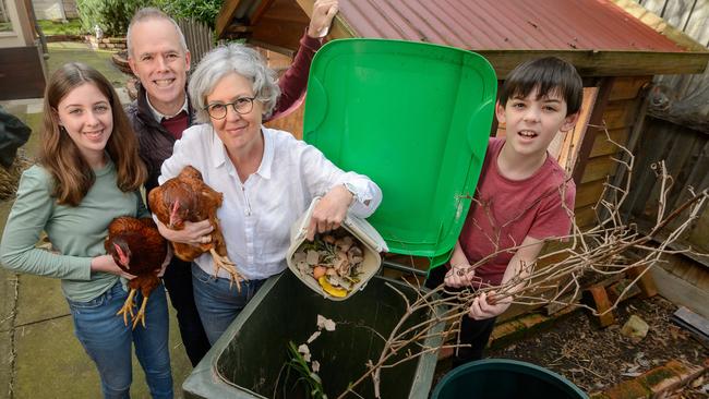 Cate Barry with her family Brendan, Rachael, 13, and Benjamin, 11. and their chooks Lola and Cate and dog Coco with all their recycling set-up. Picture: Jay Town