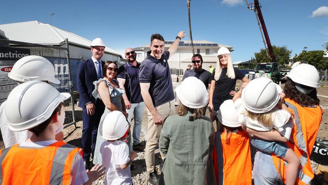 The Wilkinson children listen on as Greg Heaton from Metricon, along with MP Sam O'Connor, Andy Pesut from Capitol Concrete, Danielle and Rhys Carroll and organizer Tamika Smith, explains what builders are doing during the construction of their new house. Picture Glenn Hampson