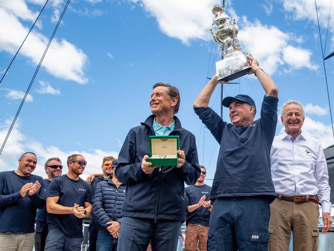 Celestial Skipper Sam Haynes is presented with the Tattersalls cup by vice commodore of the Cruising Yacht club of Australia David Jacobs and a timepiece was presented by Laurent Delaney of Rolex for winning the overall honours for the 2024 Rolex Sydney to Hobart Picture: Linda Higginson