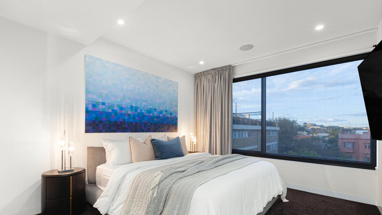 The master suite includes walk-in and built-in robes, a marble ensuite and sweeping views across the foreshore.