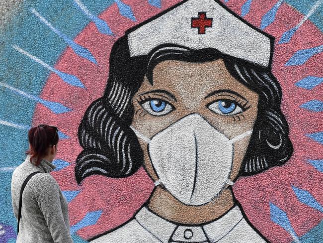 A woman looks at a coronavirus graffiti in Hamm, Germany. Picture: AP