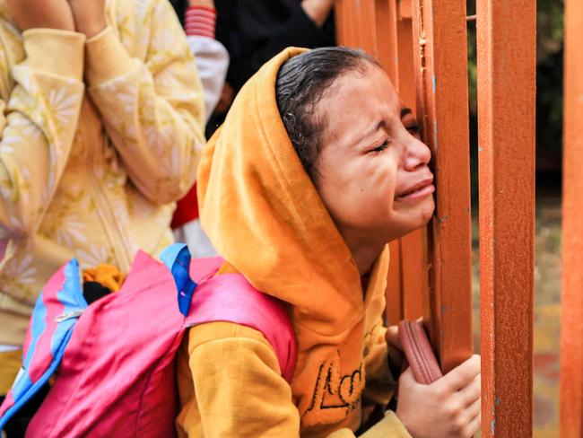 EDITORS NOTE: Graphic content / People mourn as they stand behind a metal fence near the bodies of victims who were killed in Israeli bombardment before their burial, at Nasser hospital in Khan Yunis in the southern Gaza Strip on November 14, 2023 amid the ongoing battles between Israel and the Palestinian militant group Hamas. More than 11,000 people have been killed in relentless Israeli bombardment of the Gaza Strip, according to the Hamas-run health ministry, since the war erupted after Palestinian militants raided southern Israel on October 7 killing at least 1200 people, according to official Israeli figures. (Photo by MAHMUD HAMS / AFP)