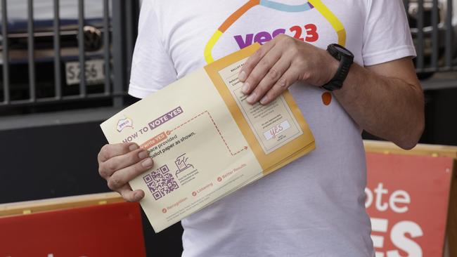 A Yes campaign volunteer gives out how to vote cards in Adelaide. Picture: NCA NewsWIRE / Emma Brasier