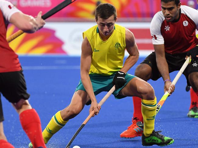 Lachlan Sharp (C) of Australia controls the ball during the men's field hockey match between Australia and Canada at the 2018 Gold Coast Commonwealth Games on April 10, 2018. / AFP PHOTO / Anthony WALLACE