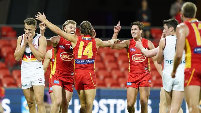 Suns players celebrate after Lachie Weller kicked a goal during the Round 3 AFL match between the Gold Coast Suns and the Adelaide Crows at Metricon Stadium on the Gold Coast, Sunday, June 21, 2020. (AAP Image/Dave Hunt)