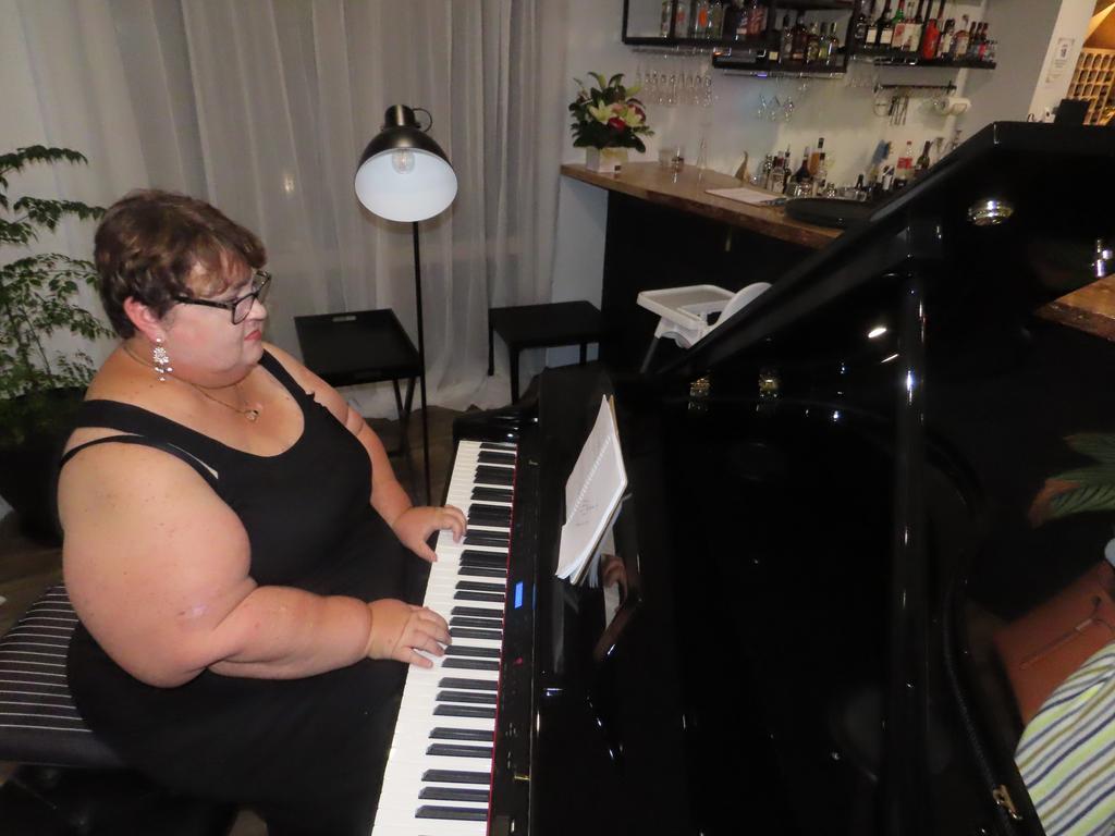 Natalie Adams playing the piano at the opening night of Tannins at Torquay.